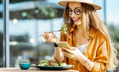 Woman smiling while eating lunch outside