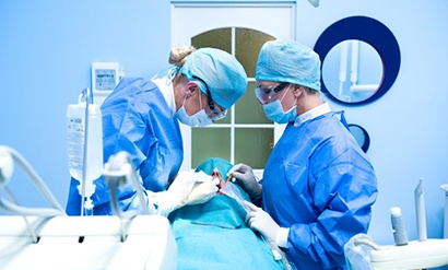 an oral surgeon performing dental implant placement surgery