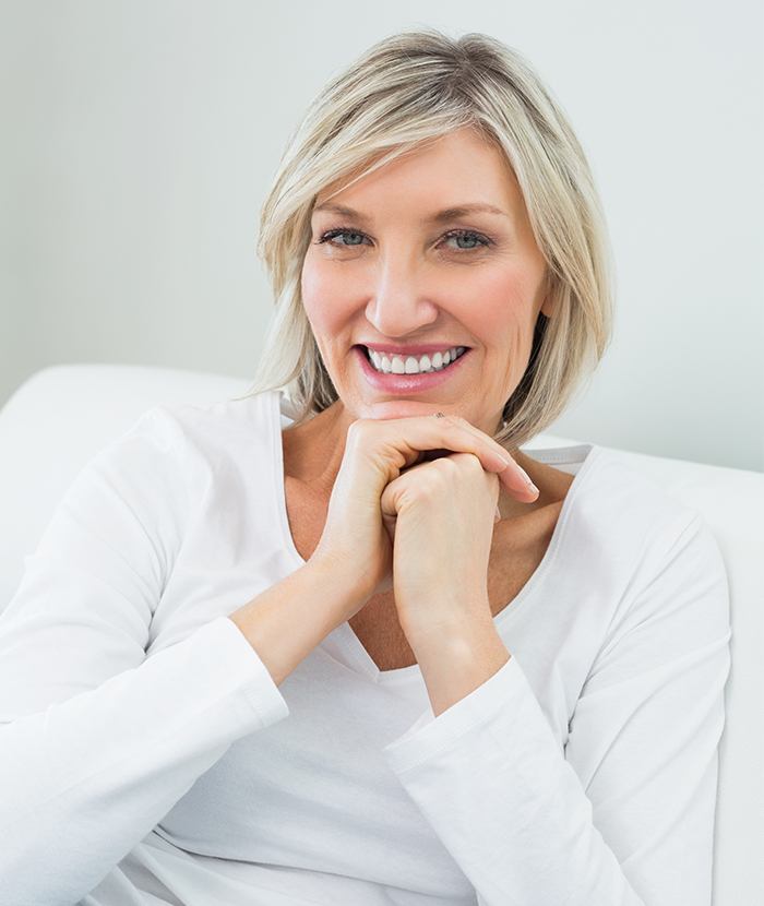 woman on white couch smiling