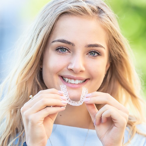 girl holding invisalign