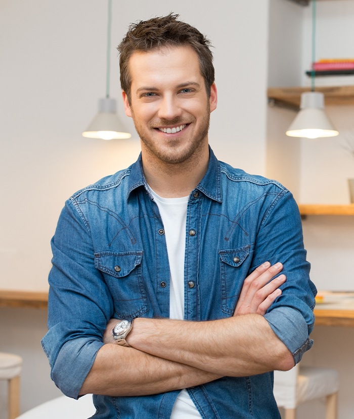 man in jean jacket smiling