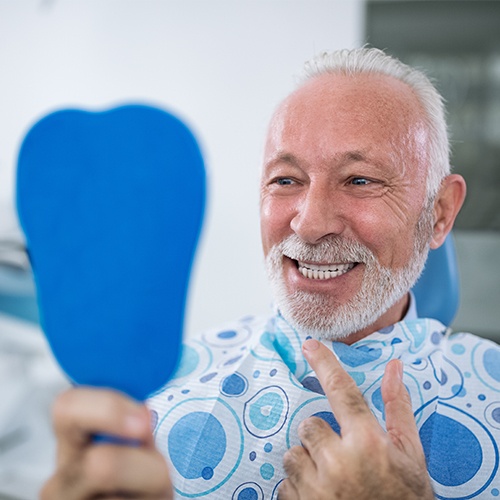 man checking our smile in blue mirror