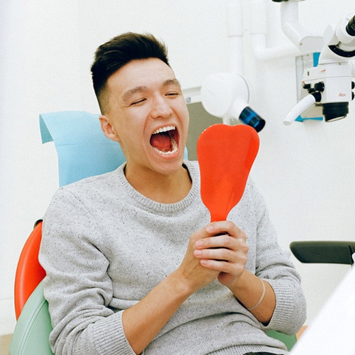 Man at dentist looking in mirror