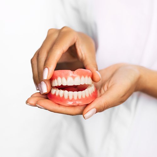 hand holding full set of dentures