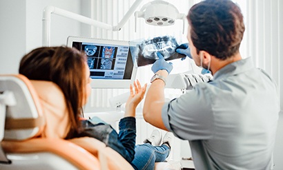 Dentist showing patient X-ray in treatment room