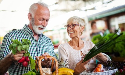 Smiling couple buying produce at farmer's market