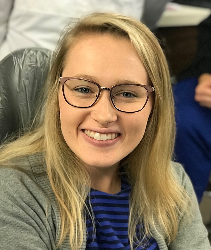 girl with glasses smiling at camera