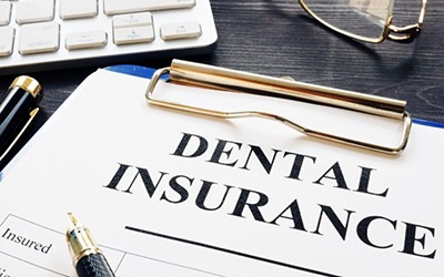 dental insurance form on a blue clipboard