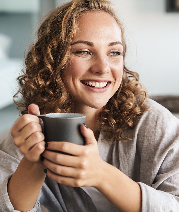 woman holding coffee cup smiling