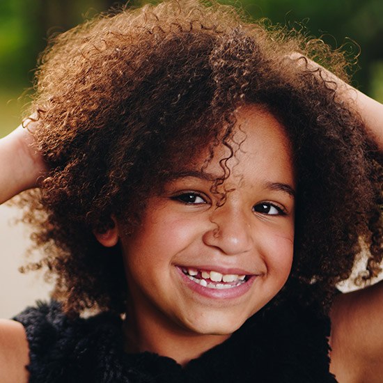 Little girl smiling outdoors