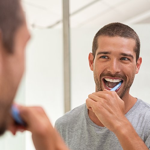 handsome man brushing teeth