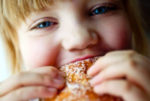 blonde girl biting into dessert 