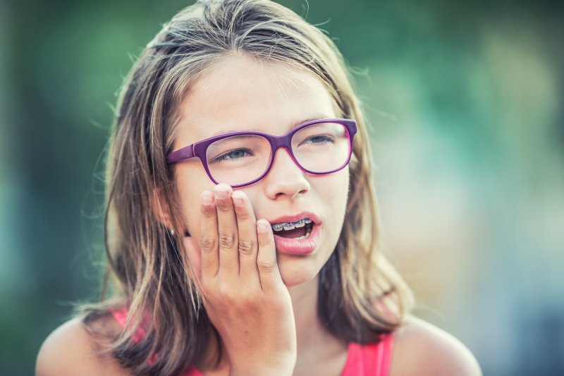 girl holding jaw in pain