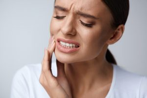 Woman with object stuck between teeth.