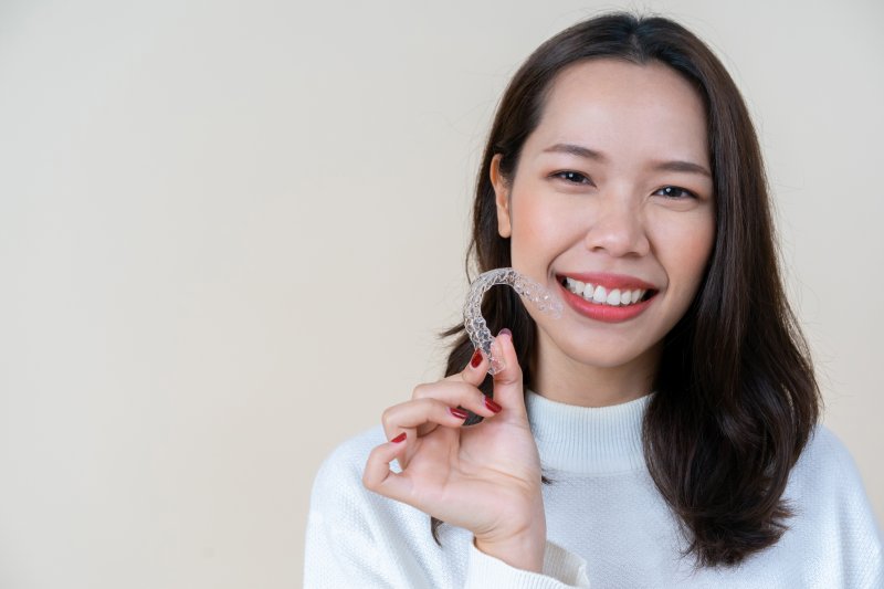 Woman holding Invisalign aligner