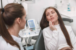 Woman with dental pain in dentist’s chair