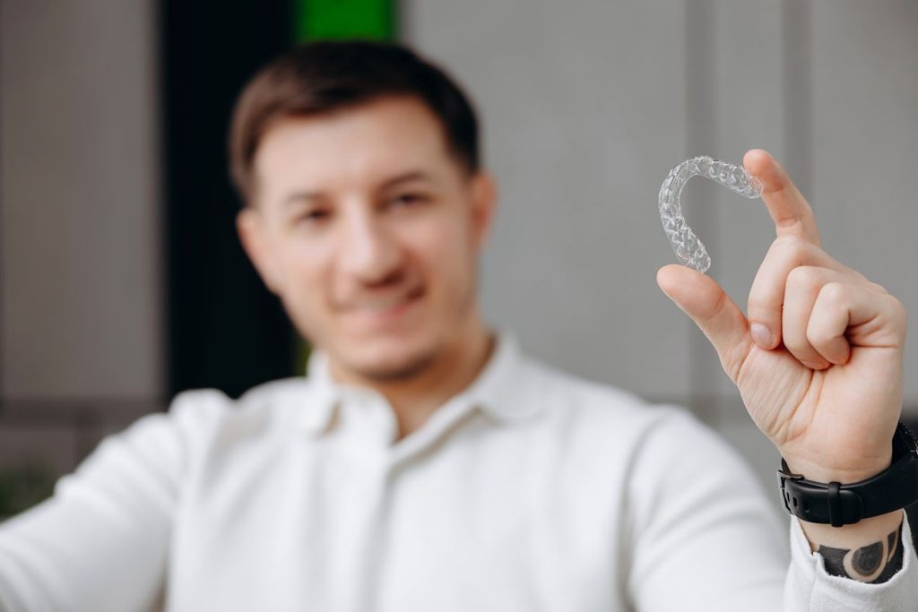 A man holding an Invisalign aligner